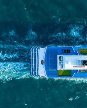 Aerial view of a catamaran sailing in blue waters.