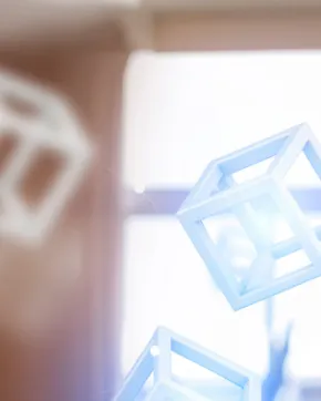 A person with a virtual reality viewer and controls, interacting with 3D cubes.