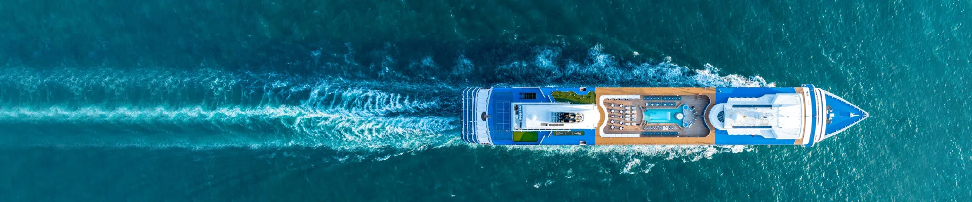 Aerial view of a catamaran sailing in blue waters.