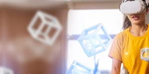 A person with a virtual reality viewer and controls, interacting with 3D cubes.